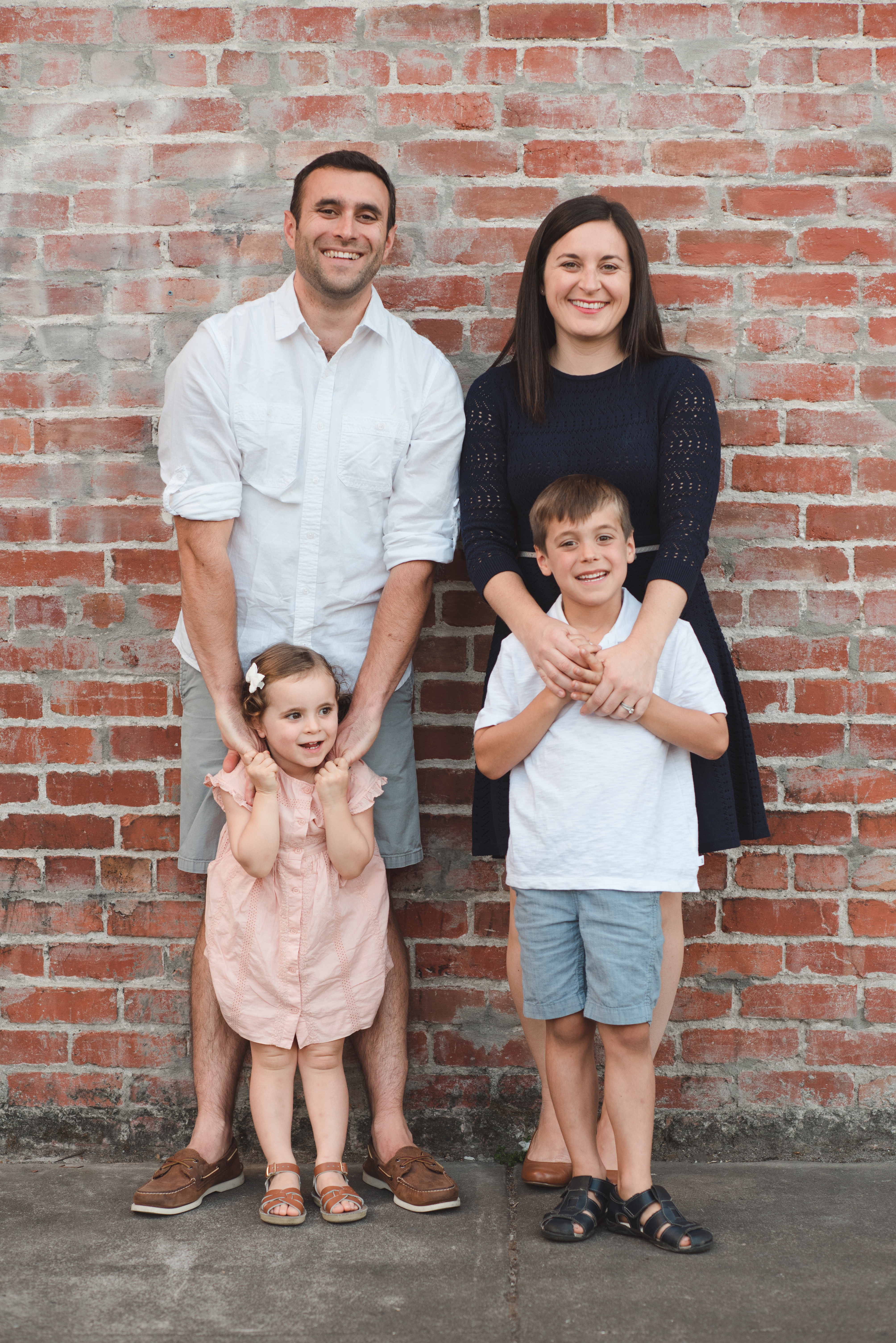 beautiful California family of 4, 4 people, 2 children, 2 adults, brick wall, smiling people, smiling family, Petaluma, downtown Petaluma